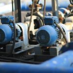 Blå industrimotorer och pumpar med kablar i en teknisk installation
