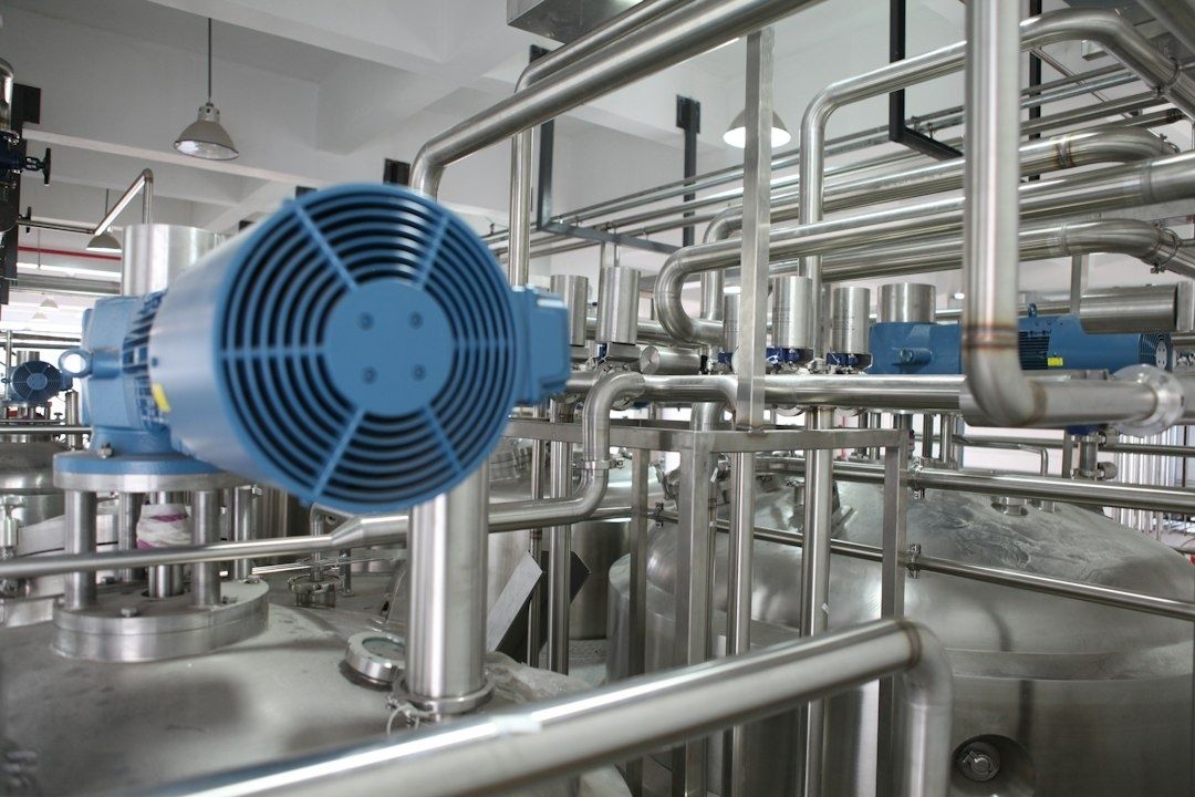 Blå elmotorer och rostfria rör i en industriell processanläggning